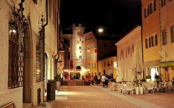 BRUNICO, ITALY AUGUST 12, 2022: People walking at night in the center of Brunico in the province of Bolzano,South Tyrol,Italy.