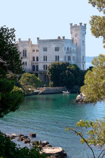 Side view of the Castle with blue/green water and rocks in front