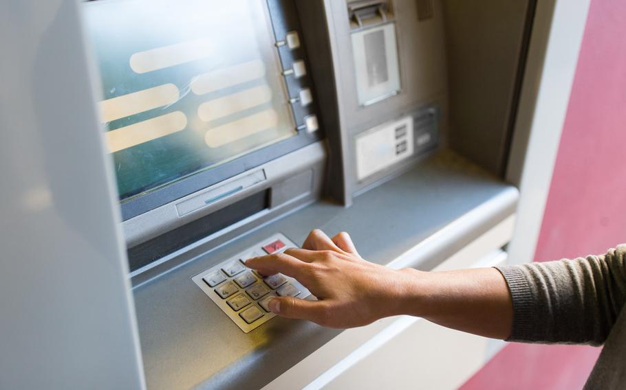 Close-up of woman using automatic teller machine to withdraw money