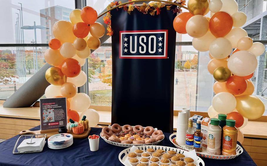 Table set up with fall color ballons, coffee, coffee creamer and pastries