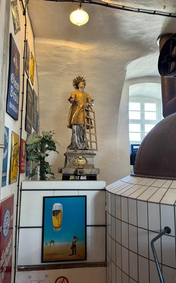 a gold statue of Saint Lawrence right above the entrance to stairs