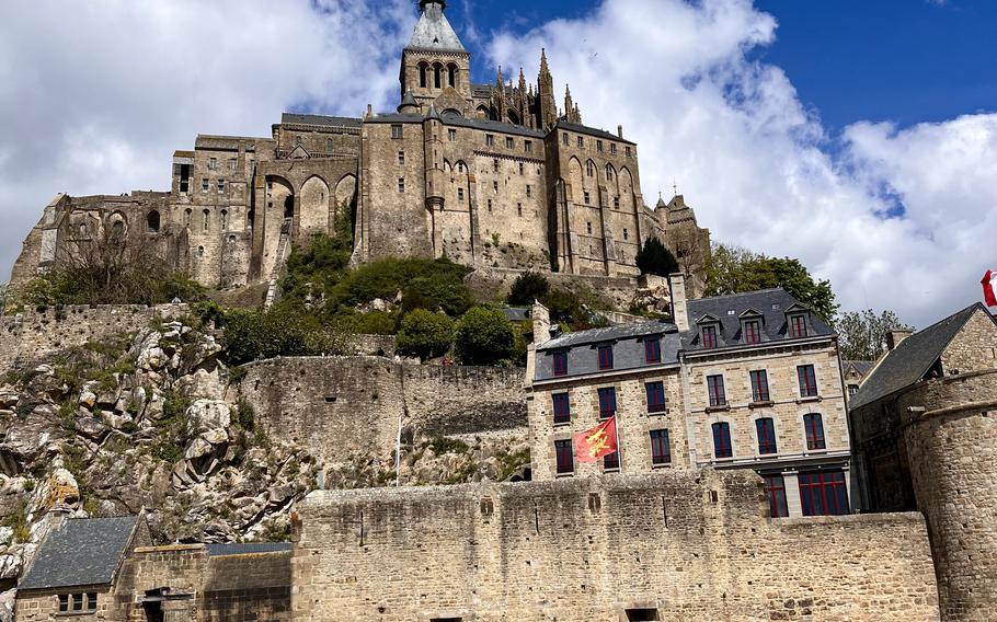 An up-close picture of the sand-colored, castle structure of Mont-Saint-Michel against a bright blue sky