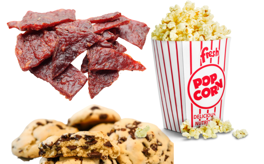 The picture features three items that could appear in a care package sent to a deployed service member with a white background. In the top left corner is beef jerkey stripes, on the right side is a small/individual bag of popcorn in a traditioal red and white striped popcorn bag with some popcorn kernals overflowing out of the bag and onto the ground. In the bottom left and center areas are a pile of chocolate chip cookies with the two cookies that are front and center seemingly broken apart in the center of the cookie with the broken areas facing the reader.