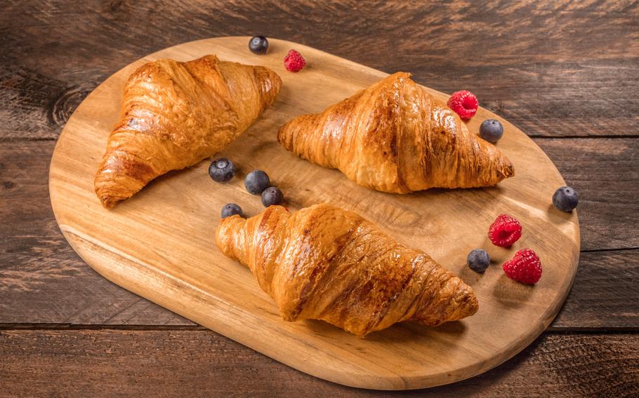 Croissants and berries on wooden board