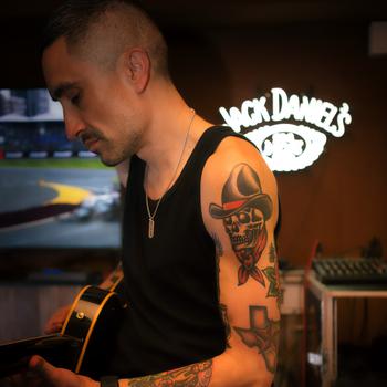 Phil Eskridge facing profile and looking down at his guitar