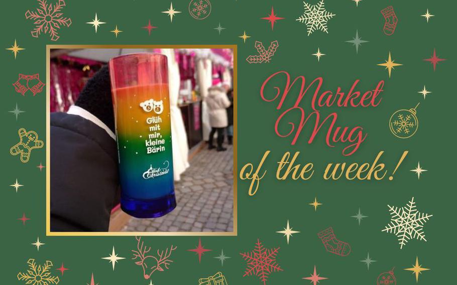 An up-close photo of a tall rainbow-striped Christmas market mug with hot chocolate in it.  