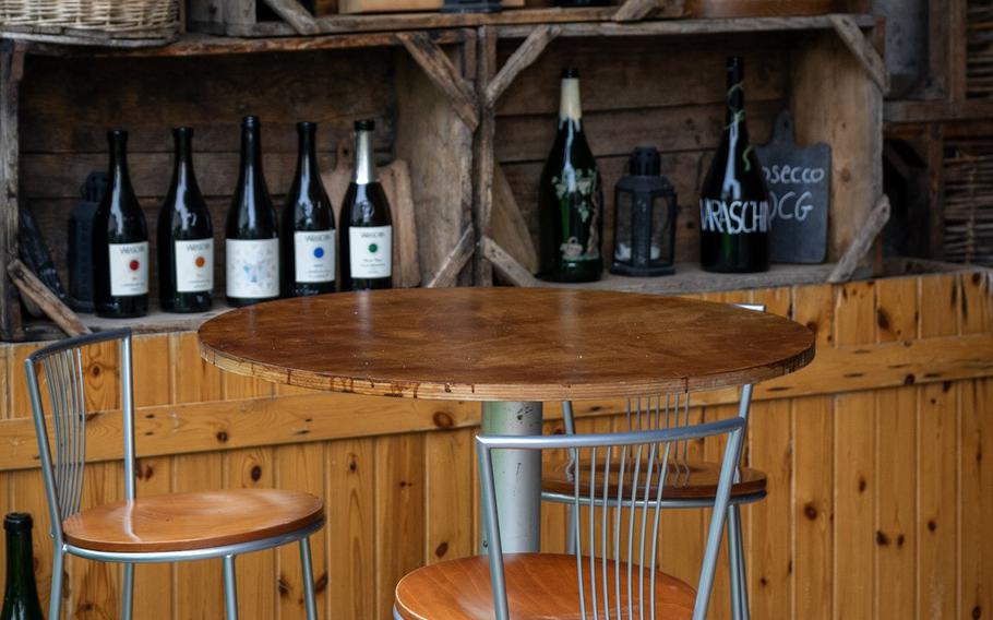 Empty barstools and table in front of a wine bar