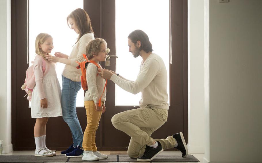 Parents helping children at door