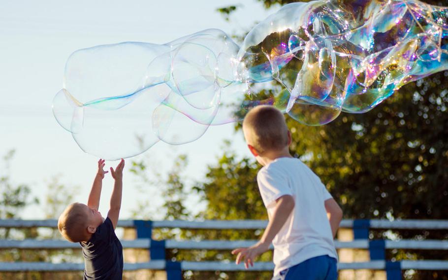 Boys reaching up for bubbles