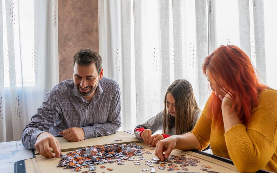 Family completing a jigsaw puzzle