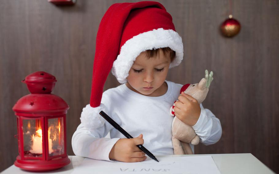 Kid in Santa hat writing letter