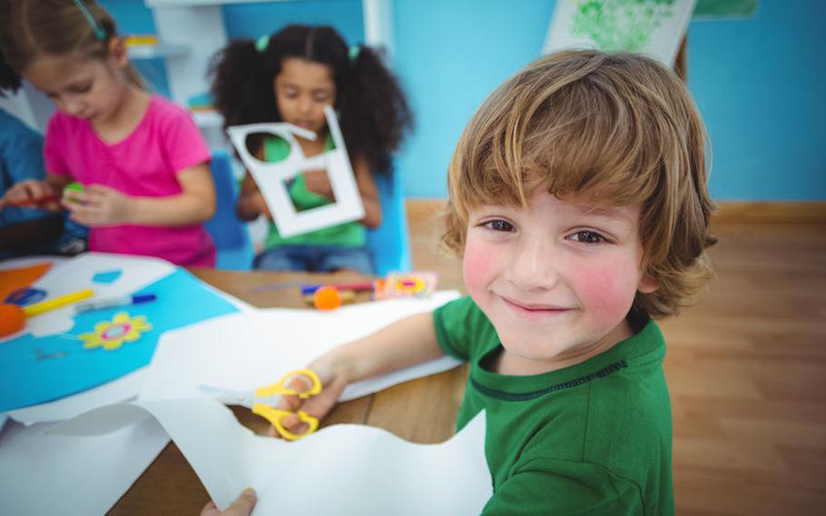 Kid sitting at table with craft.