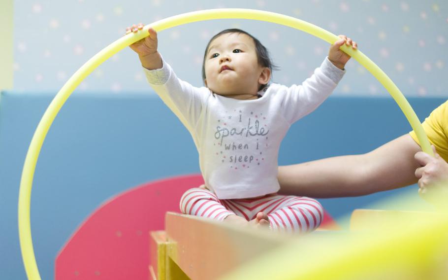 Baby holding hula hoop