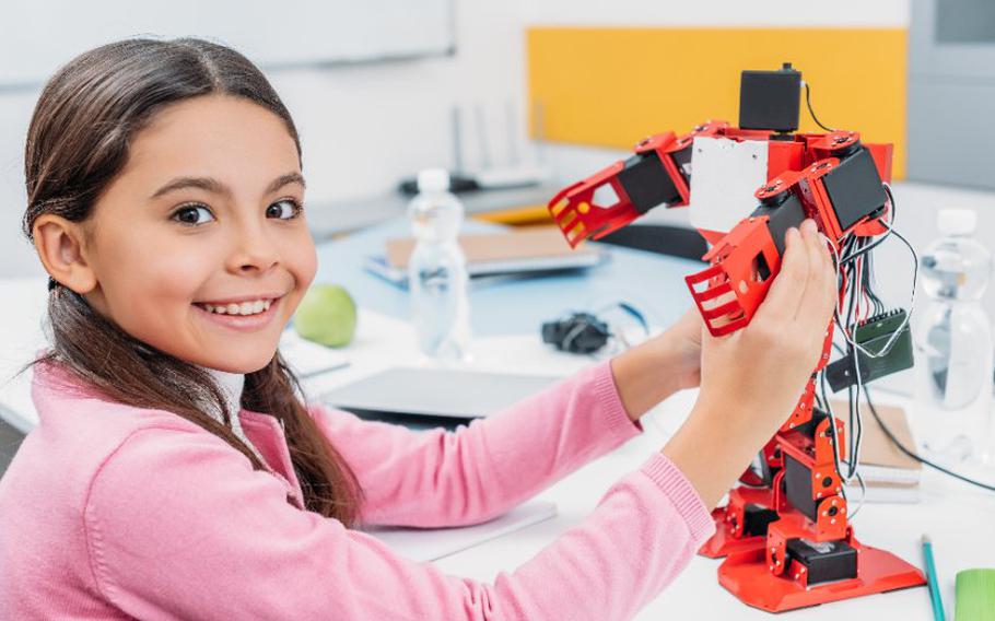 Child holding STEM materials.