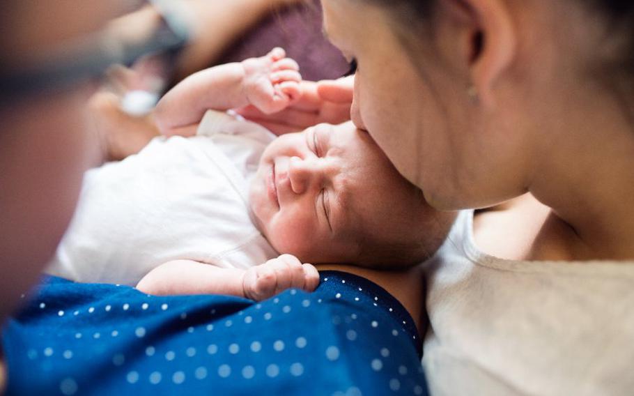 Parents holding their newborn baby boy in the arms