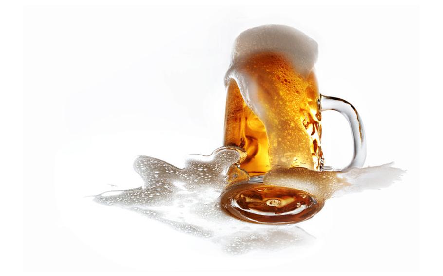 Beer glass with foam spilling out