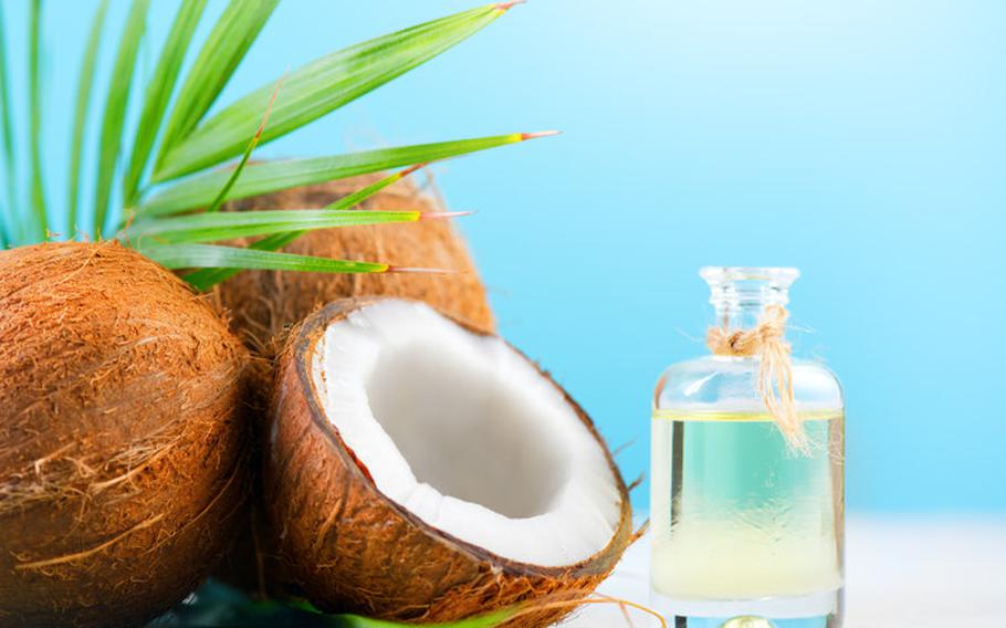 Coconut oil in bottle next to coconut