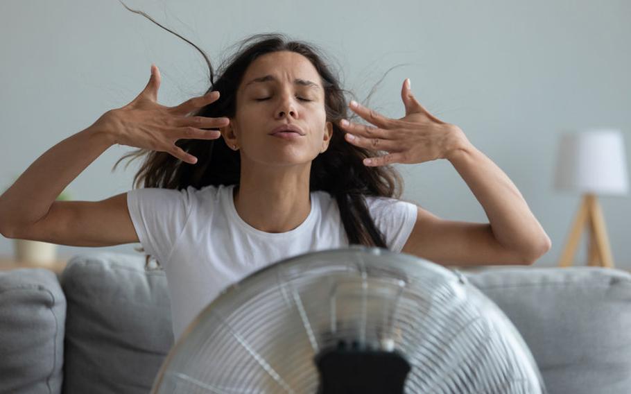 Woman cooling off in front of fan