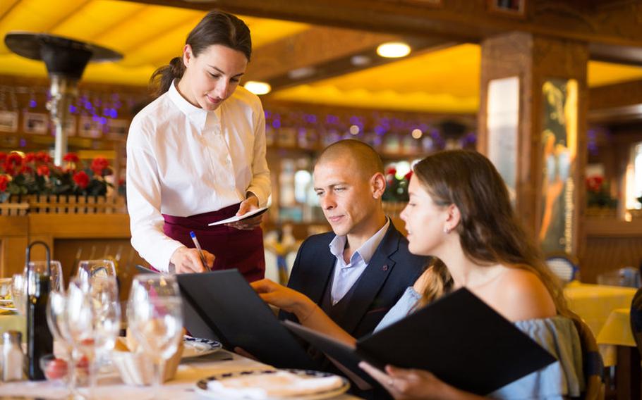 Couple holding open menus ordering at a restaurant