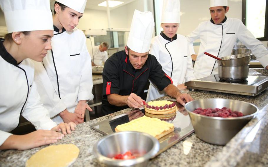 Students looking at pastry chef instructor