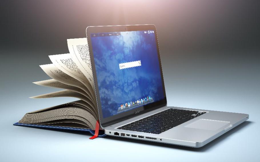 Book opening up and leaning against a laptop