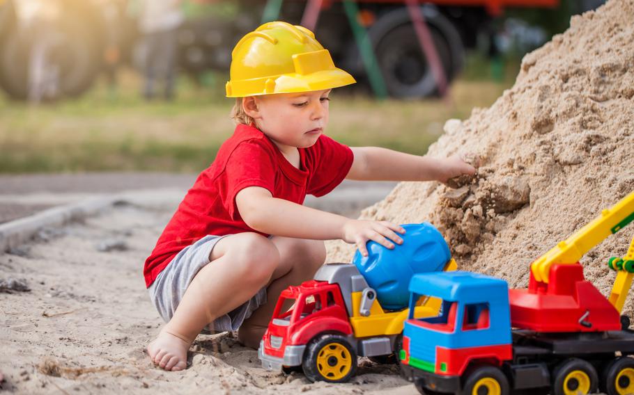 Child with vehicles in the sand