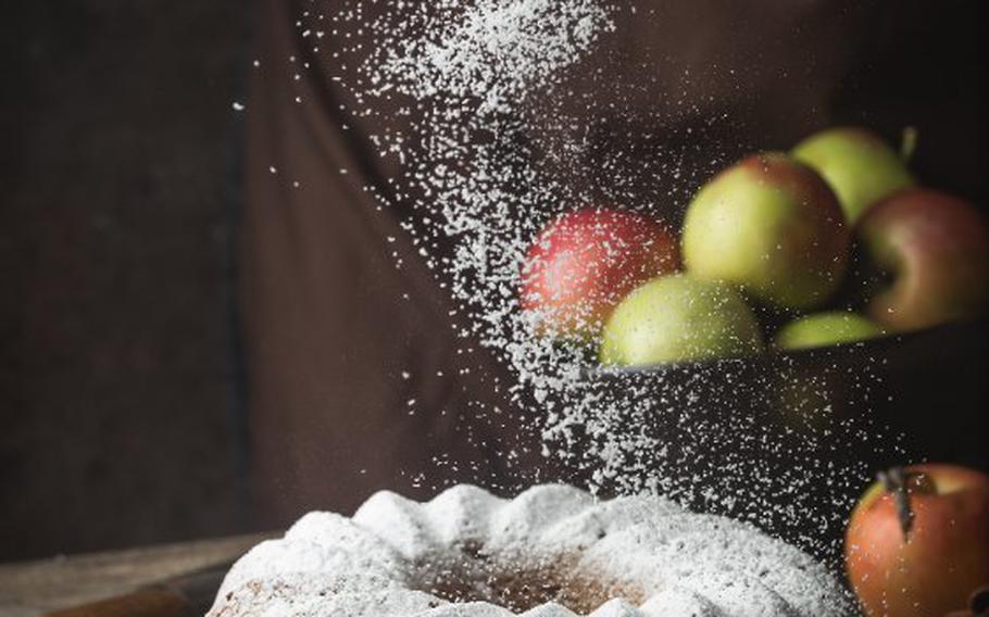 Apple Bundt cake sprinkled with icing sugar.