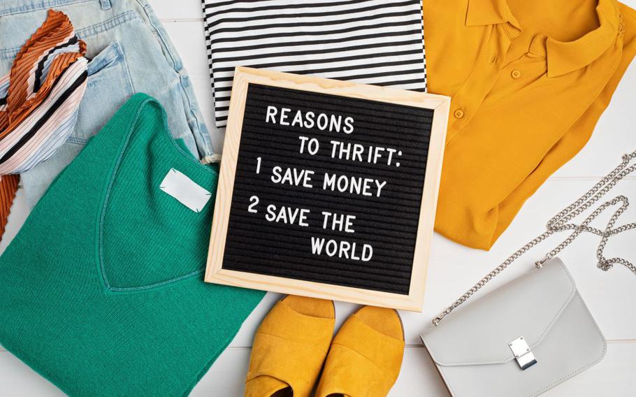 Sign that reads "Reasons to thrift: 1. Save Money 2. Save the World" on top of clothes