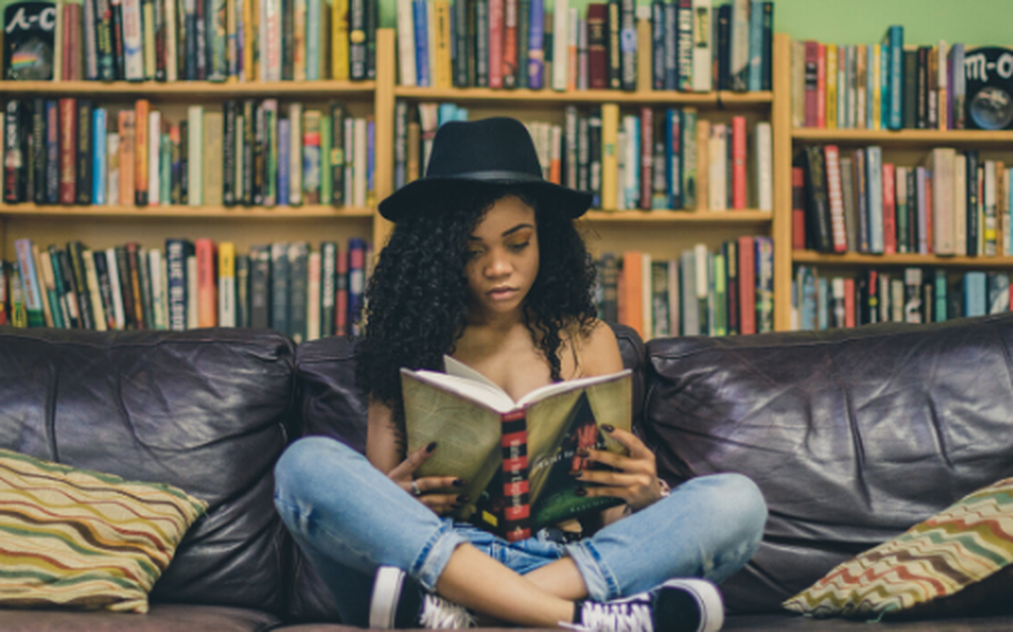 Woman sitting with legs crossed reading