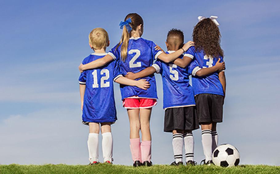 Kids facing backwards with soccer ball