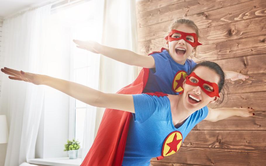 Mother and child dressed up as super heroes playing together