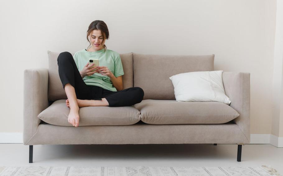 Woman holding cell phone on couch