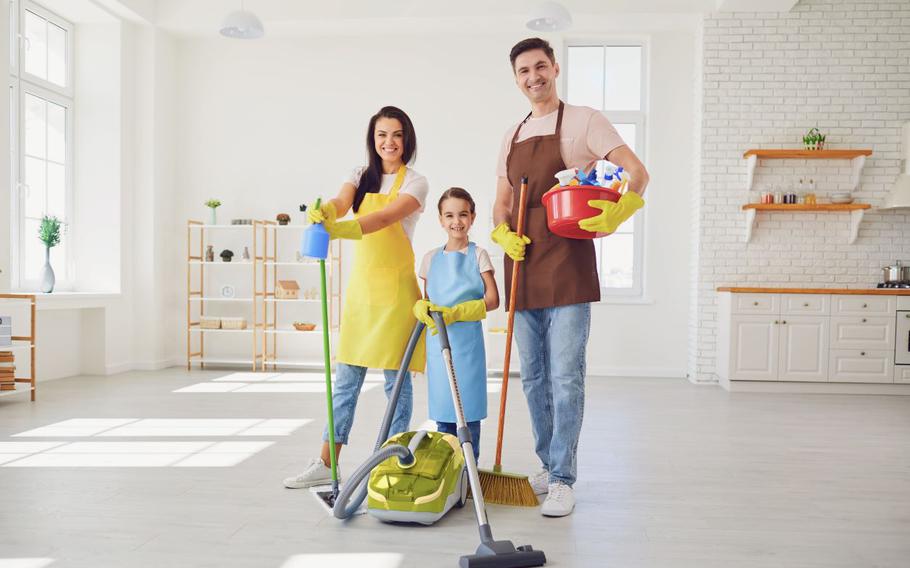 Family holding cleaning supplies