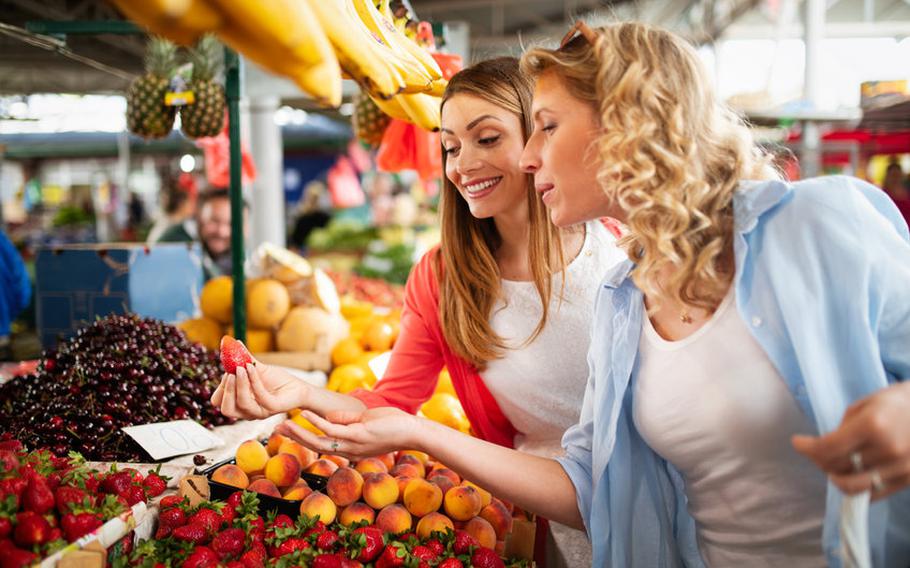 Women looking at vegetables at farmers market