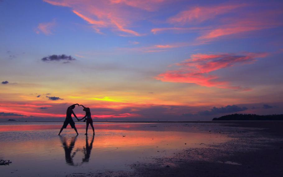 Couple on beach at sunset.